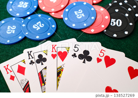 Full House Combination Playing cards spread beside casino chips on green felt gambling table Full House Combination Playing cards spread beside casino chips on green felt gambling table 138527269