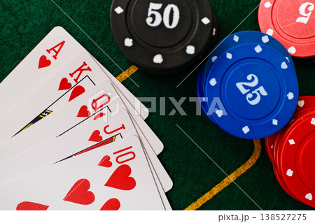 Royal Flush Combination Playing cards spread beside casino chips on green felt gambling table Royal Flush Combination Playing cards spread beside casino chips on green felt gambling table 138527275