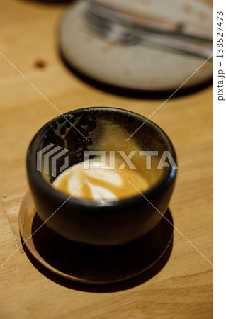 Cup of hot milk piccolo latte coffee on table. Cup of hot milk piccolo latte coffee on table. 138527473