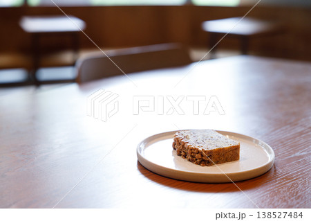 a piece of banana bread cake on table by the window. 138527484