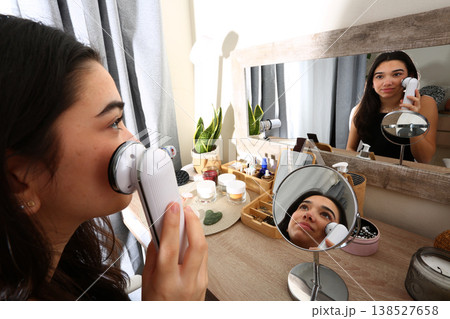 Teen Girl Using Facial Radiofrequency Device at Mirror Teen Girl Using Facial Radiofrequency Device at Mirror 138527658