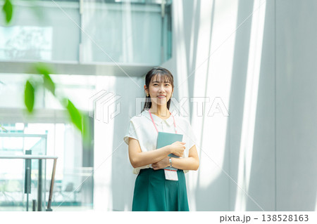 手帳を持って廊下を歩く若い女性 138528163