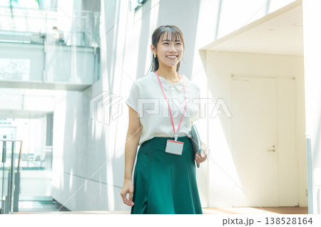 手帳を持って廊下を歩く若い女性 138528164