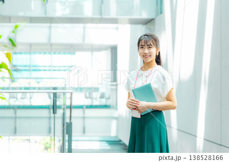 手帳を持って廊下を歩く若い女性 138528166