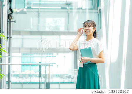 手帳を持って廊下を歩く若い女性 手帳を持って廊下を歩く若い女性 138528167