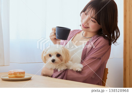 マルチーズを抱いてコーヒーを飲む女性 ペットとくつろぐ朝のライフスタイル マルチーズを抱いてコーヒーを飲む女性 ペットとくつろぐ朝のライフスタイル 138528968