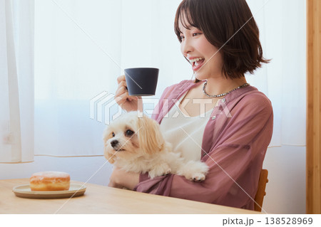 マルチーズを抱いてコーヒーを飲む女性 ペットとくつろぐ朝のライフスタイル マルチーズを抱いてコーヒーを飲む女性 ペットとくつろぐ朝のライフスタイル 138528969
