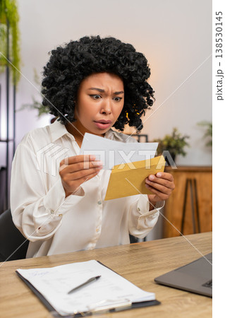 African American businesswoman reads letter frowns sad at tough email job rejection or lost chance African American businesswoman reads letter frowns sad at tough email job rejection or lost chance 138530145