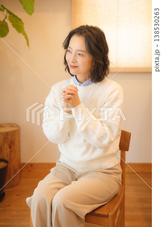 自宅で故人に祈りを捧げるミドル女性 自宅で故人に祈りを捧げるミドル女性 138530263