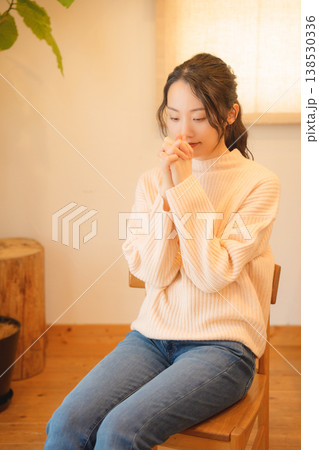 自宅で故人に祈りを捧げる娘 自宅で故人に祈りを捧げる娘 138530336
