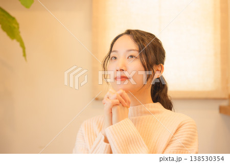 自宅で故人に祈りを捧げる娘 自宅で故人に祈りを捧げる娘 138530354