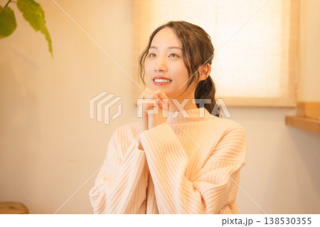 自宅で故人に祈りを捧げる娘 自宅で故人に祈りを捧げる娘 138530355