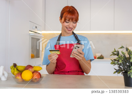 Young woman at bar checks grocery order on smartphone confirms payment with bank card approval done Young woman at bar checks grocery order on smartphone confirms payment with bank card approval done 138530383