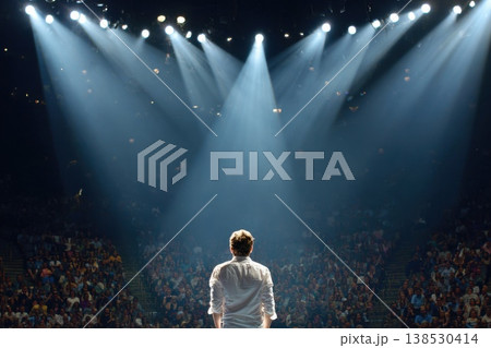 Comedian on Stage with Backstage View and Spotlight Lighting in a Packed Auditorium 138530414