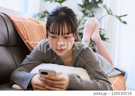 スマートフォンを楽しむ女性 リビングでくつろぐライフスタイル スマートフォンを楽しむ女性 リビングでくつろぐライフスタイル 138530519