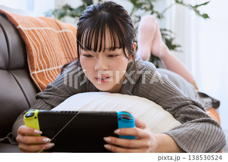 携帯ゲーム機で遊ぶ女性　自宅でくつろぐ休日 138530524