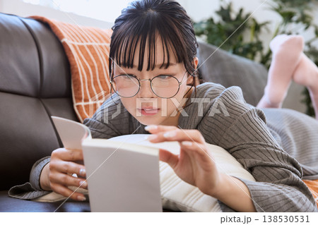 メガネをかけて本を読む女性 自宅で過ごす読書時間 メガネをかけて本を読む女性 自宅で過ごす読書時間 138530531