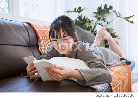 メガネをかけて本を読む女性 自宅でくつろぐ読書の時間 メガネをかけて本を読む女性 自宅でくつろぐ読書の時間 138530536
