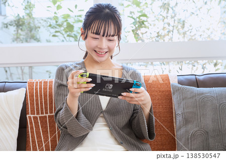 携帯ゲーム機で遊ぶ女性　自宅でくつろぐ休日 138530547