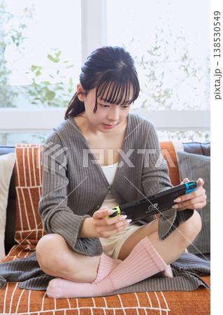 携帯ゲーム機で遊ぶ女性 自宅でくつろぐ休日 携帯ゲーム機で遊ぶ女性 自宅でくつろぐ休日 138530549