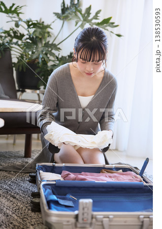 旅行の準備でスーツケースに服を詰める若い女性 138530593