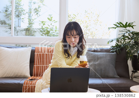 自宅でビールを楽しみながら動画を見る女性 138530862