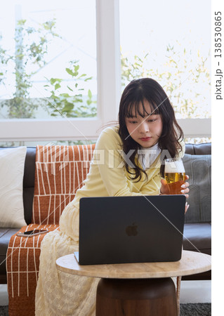 自宅でビールを楽しみながら動画を見る女性 自宅でビールを楽しみながら動画を見る女性 138530865