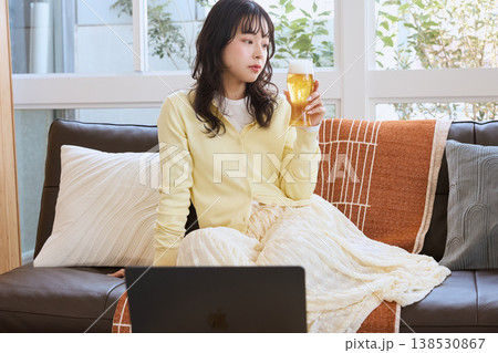 自宅でビールを楽しみながら動画を見る女性 138530867
