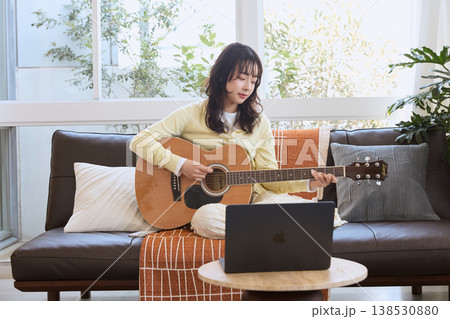 オンラインでギターを練習する若い女性 138530880