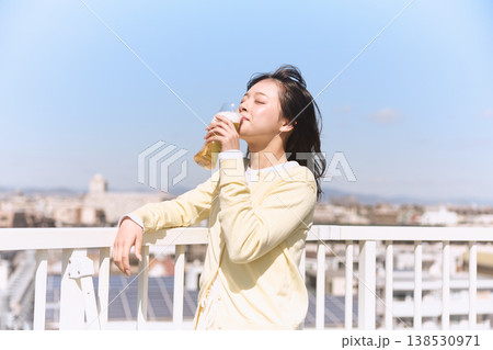 青空の下でビールを楽しむ若い女性 青空の下でビールを楽しむ若い女性 138530971