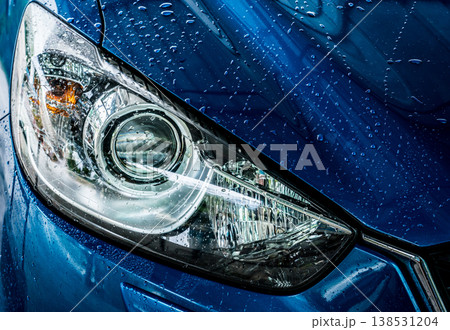 Closeup headlamp of blue car are washing with water. Car care service business concept. Car wash service. Car covered with drops of water after cleaning with high pressure water spray. Auto care. Closeup headlamp of blue car are washing with water. Car care service business concept. Car wash service. Car covered with drops of water after cleaning with high pressure water spray. Auto care. 138531204