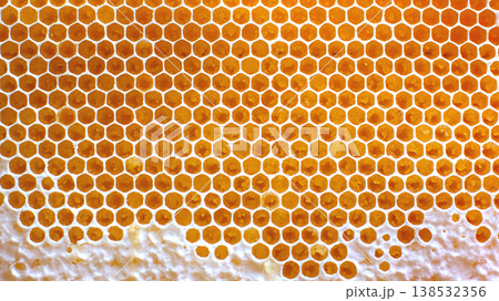 honeycomb structure showing hexagonal cells filled with honey from a beehive during daylight hours honeycomb structure showing hexagonal cells filled with honey from a beehive during daylight hours 138532356