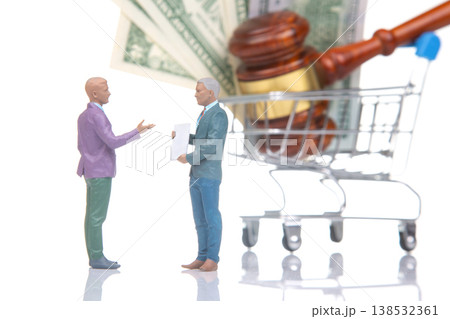 Miniature people discussing legal matters with money and a shopping cart in the background  138532361