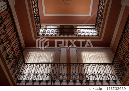 Two-story building atrium with wrought iron railings and high windows.  138532689