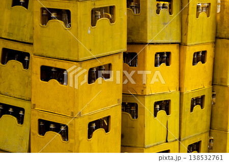 Stacked yellow plastic crates with glass bottles, industrial storage and beverage distribution concept, reusable containers for logistics and recycling, warehouse supply background Stacked yellow plastic crates with glass bottles, industrial storage and beverage distribution concept, reusable containers for logistics and recycling, warehouse supply background 138532761
