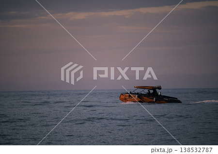 Red motorboat cruising on calm sea under soft pastel sunset sky, modern speed boat on open water with copy space, evening marine travel and leisure concept, minimal seascape composition Red motorboat cruising on calm sea under soft pastel sunset sky, modern speed boat on open water with copy space, evening marine travel and leisure concept, minimal seascape composition 138532787