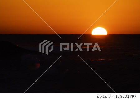 Intense red sunset over sea with bright sun and sparkling waves, dramatic reflection on water, vivid orange sky and dynamic splashes, atmospheric seascape background with strong warm tones Intense red sunset over sea with bright sun and sparkling waves, dramatic reflection on water, vivid orange sky and dynamic splashes, atmospheric seascape background with strong warm tones 138532797