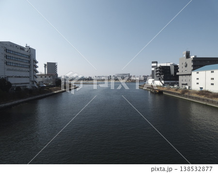 運河の両岸に並ぶビル群と遠景の都市部を望む水辺風景 運河の両岸に並ぶビル群と遠景の都市部を望む水辺風景 138532877