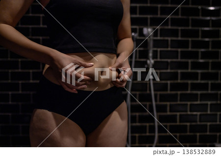 少し太ったお腹の贅肉をつまむ若い女性 太り始め お風呂 暗め 少し太ったお腹の贅肉をつまむ若い女性 太り始め お風呂 暗め 138532889