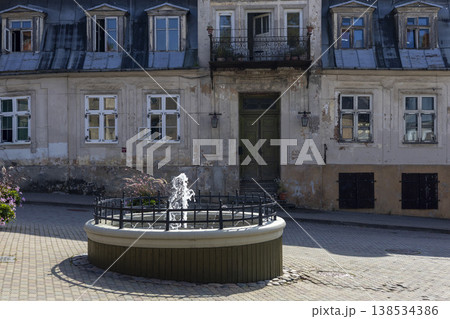 Charming fountain in the historic streets of Cesis, Latvia, surrounded by quaint architecture and vibrant flora 138534386