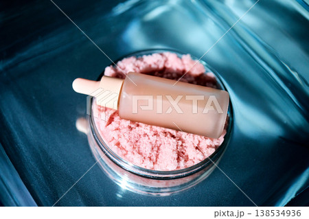 Cosmetic serum dropper bottle on pink exfoliating scrub 138534936