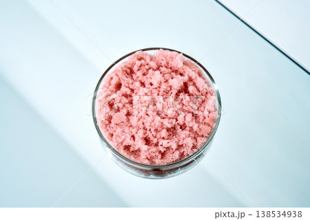 Pink sugar body scrub in glass bowl on light blue surface Pink sugar body scrub in glass bowl on light blue surface 138534938