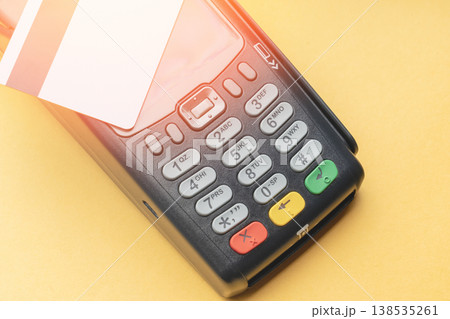 Payment terminal rests on bright yellow surface 138535261