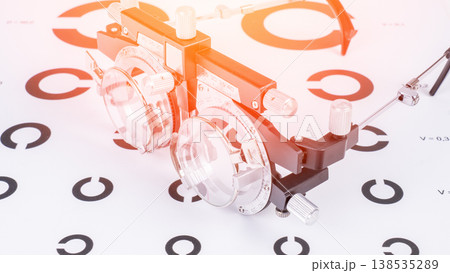 Optometric device rests on eye chart 138535289