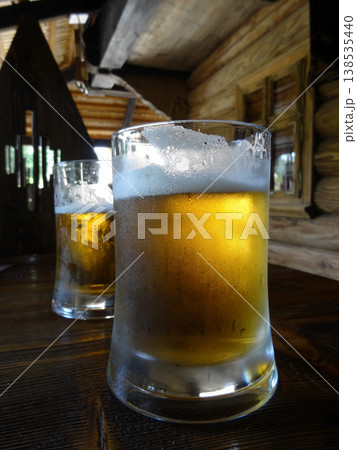 Two beer glasses on the old wooden table in country restaurant Two beer glasses on the old wooden table in country restaurant 138535440