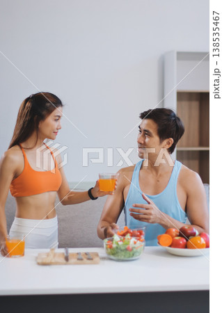 A happy couple prepares fresh vegetables, laughing and enjoying cooking a healthy meal together. A happy couple prepares fresh vegetables, laughing and enjoying cooking a healthy meal together. 138535467