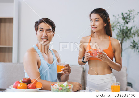 A happy couple prepares fresh vegetables, laughing and enjoying cooking a healthy meal together. 138535470