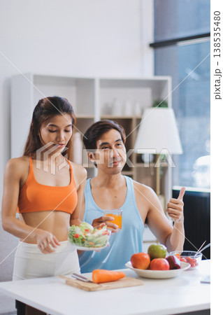 A happy couple prepares fresh vegetables, laughing and enjoying cooking a healthy meal together. A happy couple prepares fresh vegetables, laughing and enjoying cooking a healthy meal together. 138535480