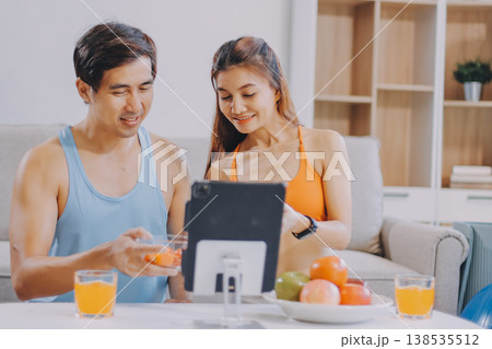 A happy couple prepares fresh vegetables, laughing and enjoying cooking a healthy meal together. A happy couple prepares fresh vegetables, laughing and enjoying cooking a healthy meal together. 138535512