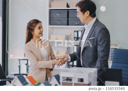 Real Estate Broker discussing with a customer model install solar roof house modern project in the office, real estate developer alternative energy, development business sustainable, zero energy, ESG. 138535560